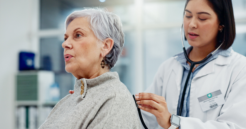  Senior woman, doctor and stethoscope for breathing on back to listen for lung problem. 